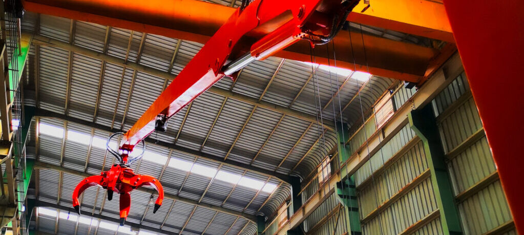 How does a Stationary Mounted Crane with Grapple compare to a Loader Tractor in terms of performance, cost efficiency, maintenance requirements, and suitability for heavy-duty stationary tasks?